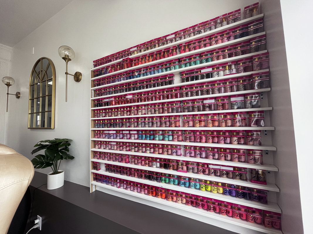 a shelf full of nail polishes in all the colors of the rainbow